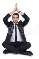 Businessman sitting in lotus pose with hands together
