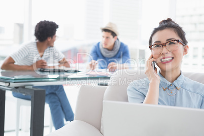 Young creative woman using laptop on couch