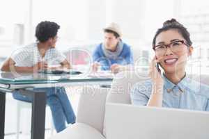 Young creative woman using laptop on couch