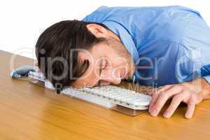 Businessman sleeping with his head on the keyboard