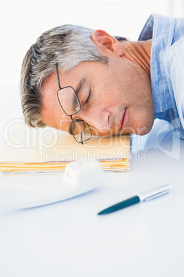 Man with glasses sleeping on his files