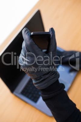 Hands with leather gloves using laptop and smartphone