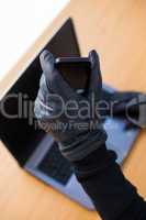 Hands with leather gloves using laptop and smartphone