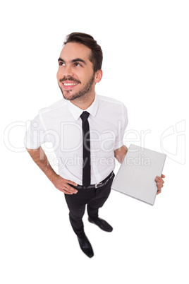 Happy businessman holding laptop and looking up