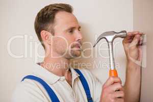 Man hammering nail in the wall