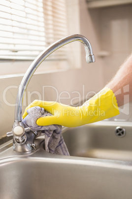 Hand cleaning a sink with cloth
