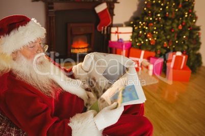 Father christmas reading newspaper on the couch