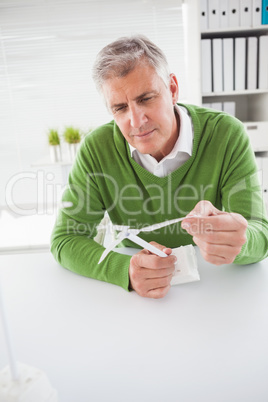 Casual businessman looking at model wind turbines