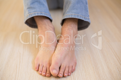 Mans bare feet on wooden floor