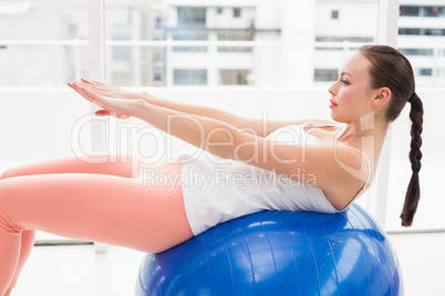 Fit brunette stretching on an exercise ball