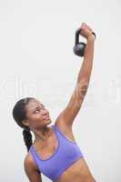 Fit woman lifting up kettlebell