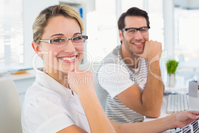 Photo editors smiling to the camera with hands under chin