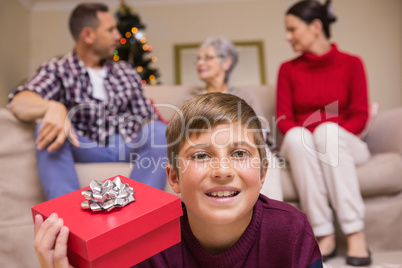 Smiling son with gift in front of his family