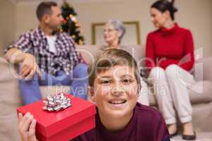 Smiling son with gift in front of his family
