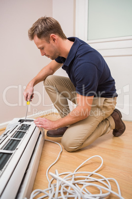 Focused handyman fixing air conditioning