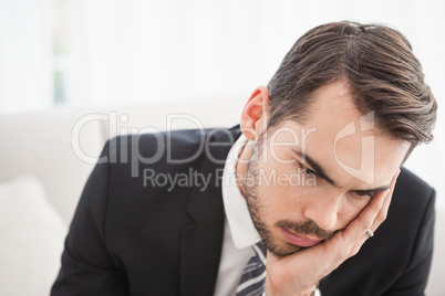 Worried businessman sitting on his couch