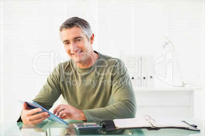 Smiling casual man using tablet pc