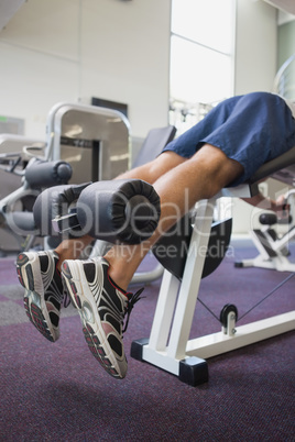 Fit man using weights machine for legs