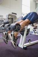 Fit man using weights machine for legs