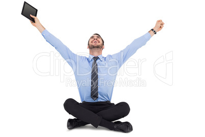 Businessman cheering and holding his tablet