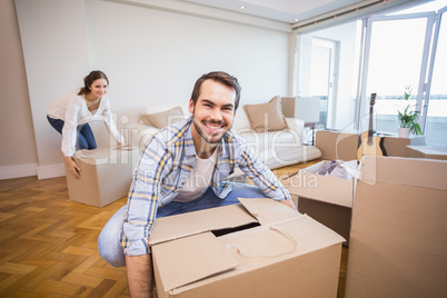 Cute couple unpacking cardboard boxes