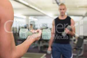 Blurred man exercising with dumbbell in gym