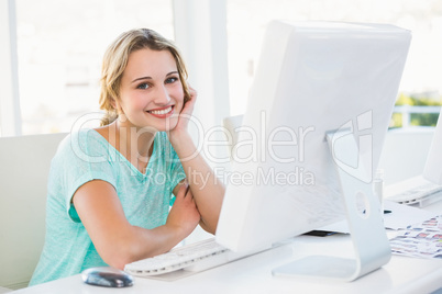 Smiling creative businesswoman posing holding her head