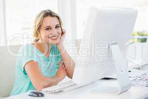 Smiling creative businesswoman posing holding her head