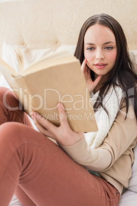 Pretty brunette reading on her bed Pretty brunette reading on her bed