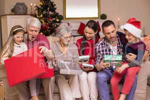 Multi generation family opening gifts on sofa