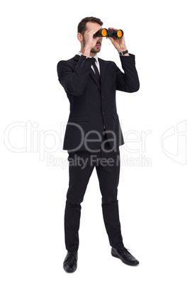 Elegant businessman standing and using binoculars