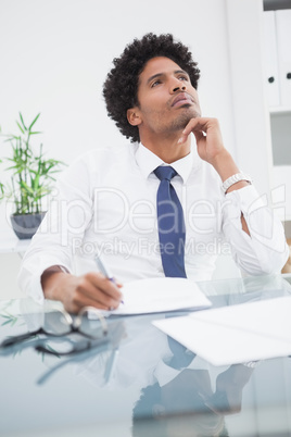 Businessman in shirt writing and thinking