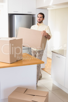 Young man unpacking boxes in kitchen