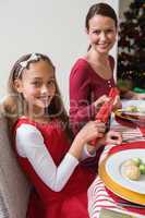 Mother and daughter pulling christmas crackers