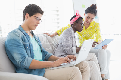 Young creative team working on couch