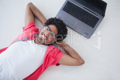 Happy businessman lying near his laptop