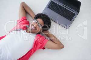 Happy businessman lying near his laptop