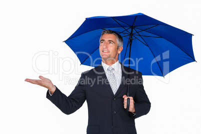 Smiling businessman under umbrella with hand out