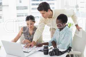 Casual business team looking at laptop together