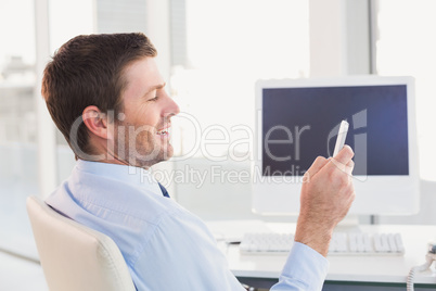 Smiling businessman sending a text Smiling businessman sending a text