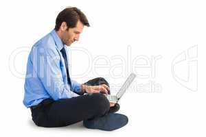 Businessman sitting on floor working on laptop