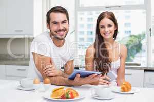 Young couple using tablet at breakfast