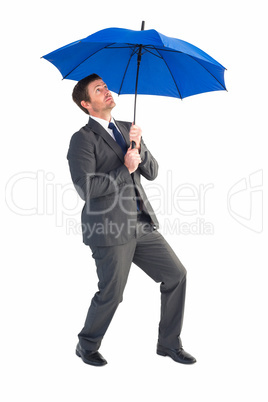 Businessman sheltering under blue umbrella Businessman sheltering under blue umbrella