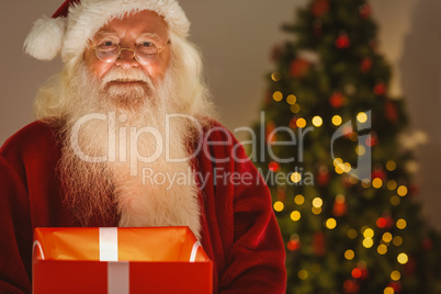Happy santa holding a glowing gift