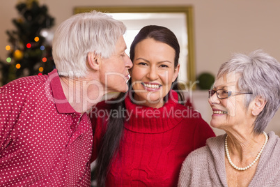 Grandfather kissing the mother at christmas
