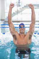 Fit swimmer cheering in pool at leisure center