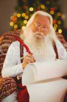 Concentrated santa writing list on the armchair