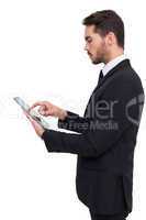Concentrated businessman touching his tablet