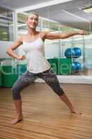 Smiling young woman doing power fitness exercise