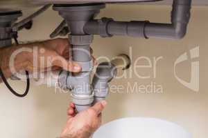 Plumber fixing under the sink